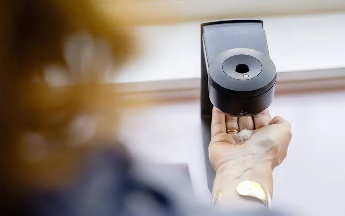 Sort LESSEAU dispenser som doserer såpe i en hånd